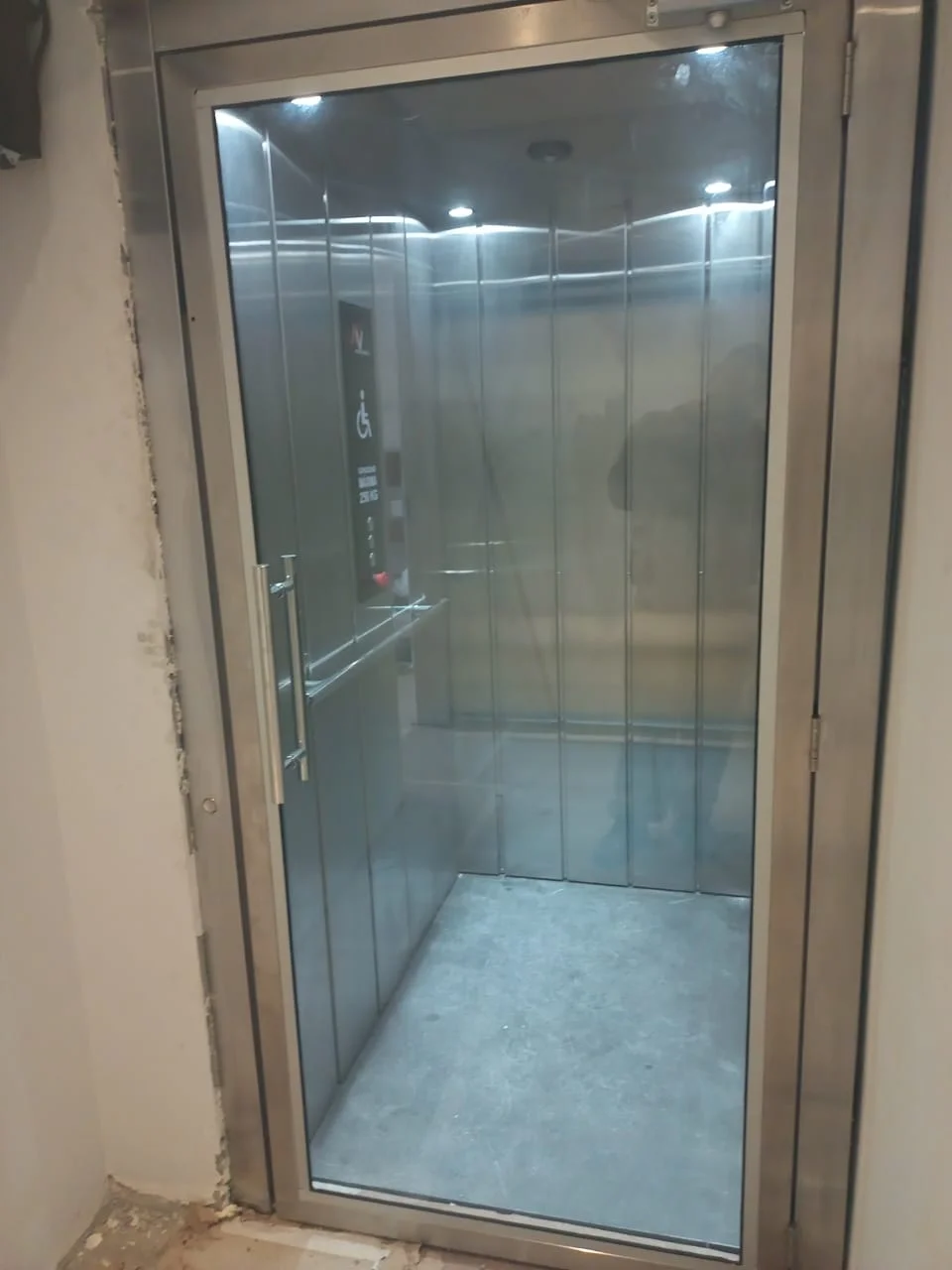 Elevador panorâmico com porta de vidro e cabine em inox