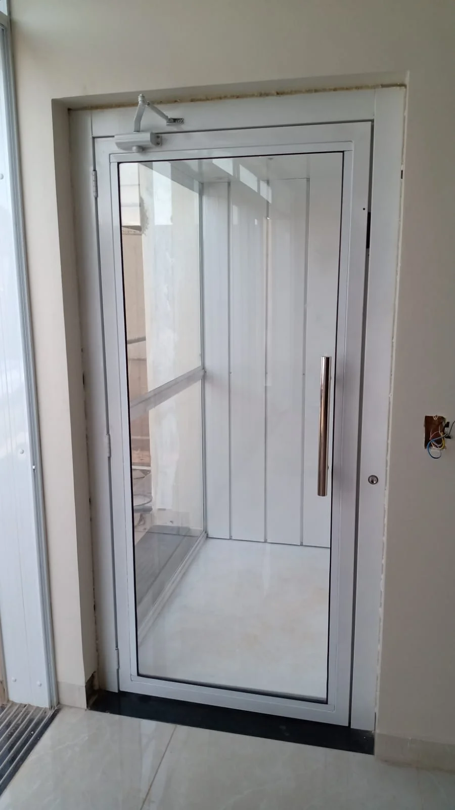 Elevador residencial branco com porta de vidro finalizado